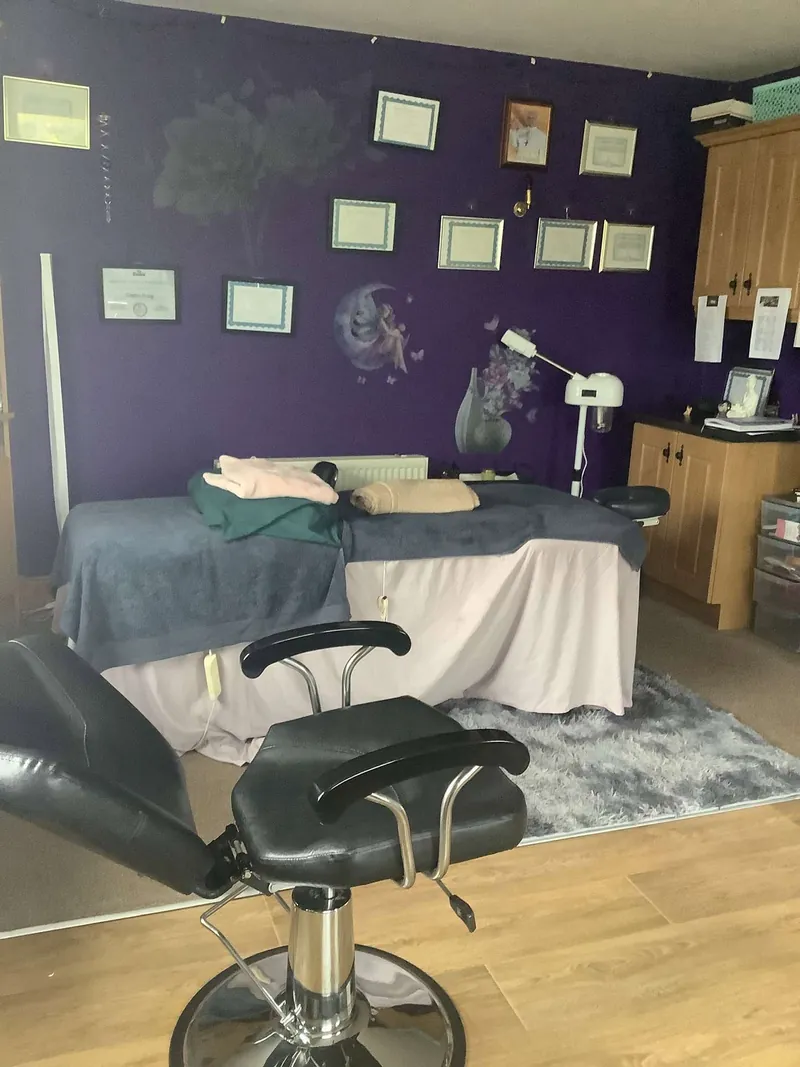 Treatment room at The Healing Room with a massage table and qualifications on display
